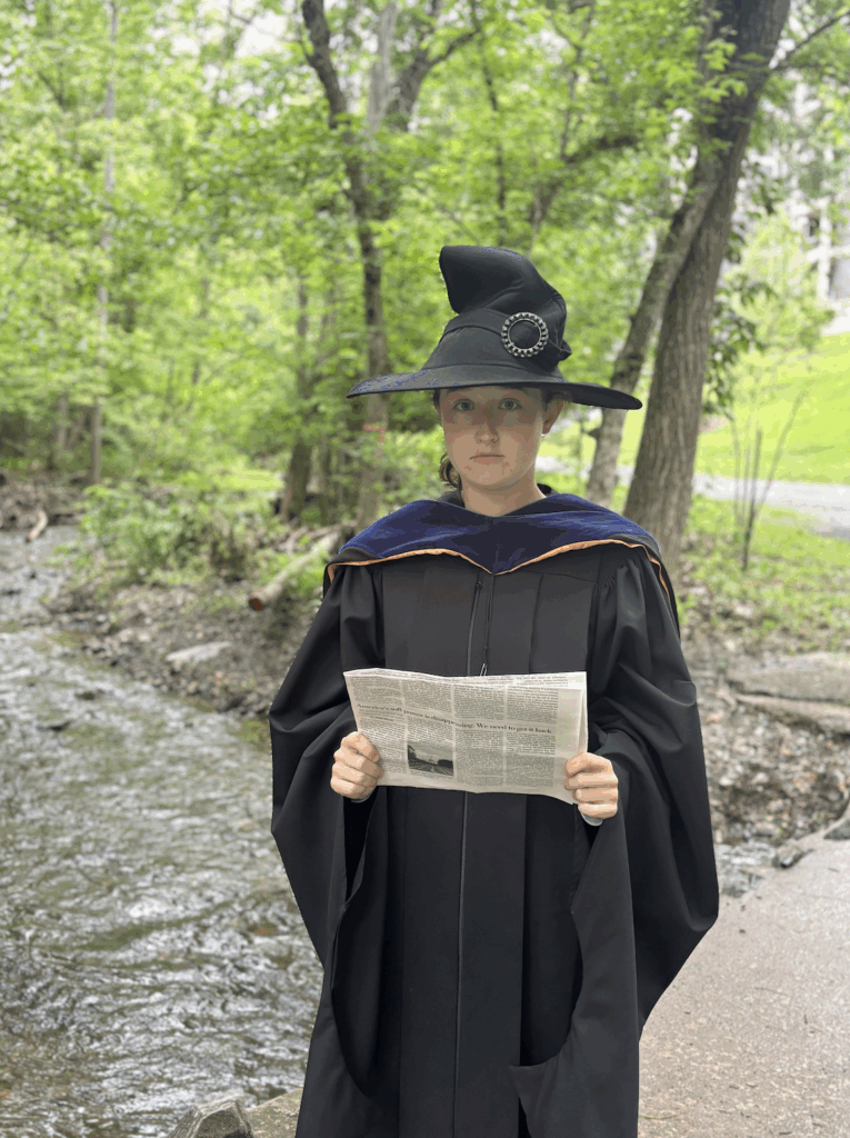 A photo of Anna Morris dressing a graduation gown. 